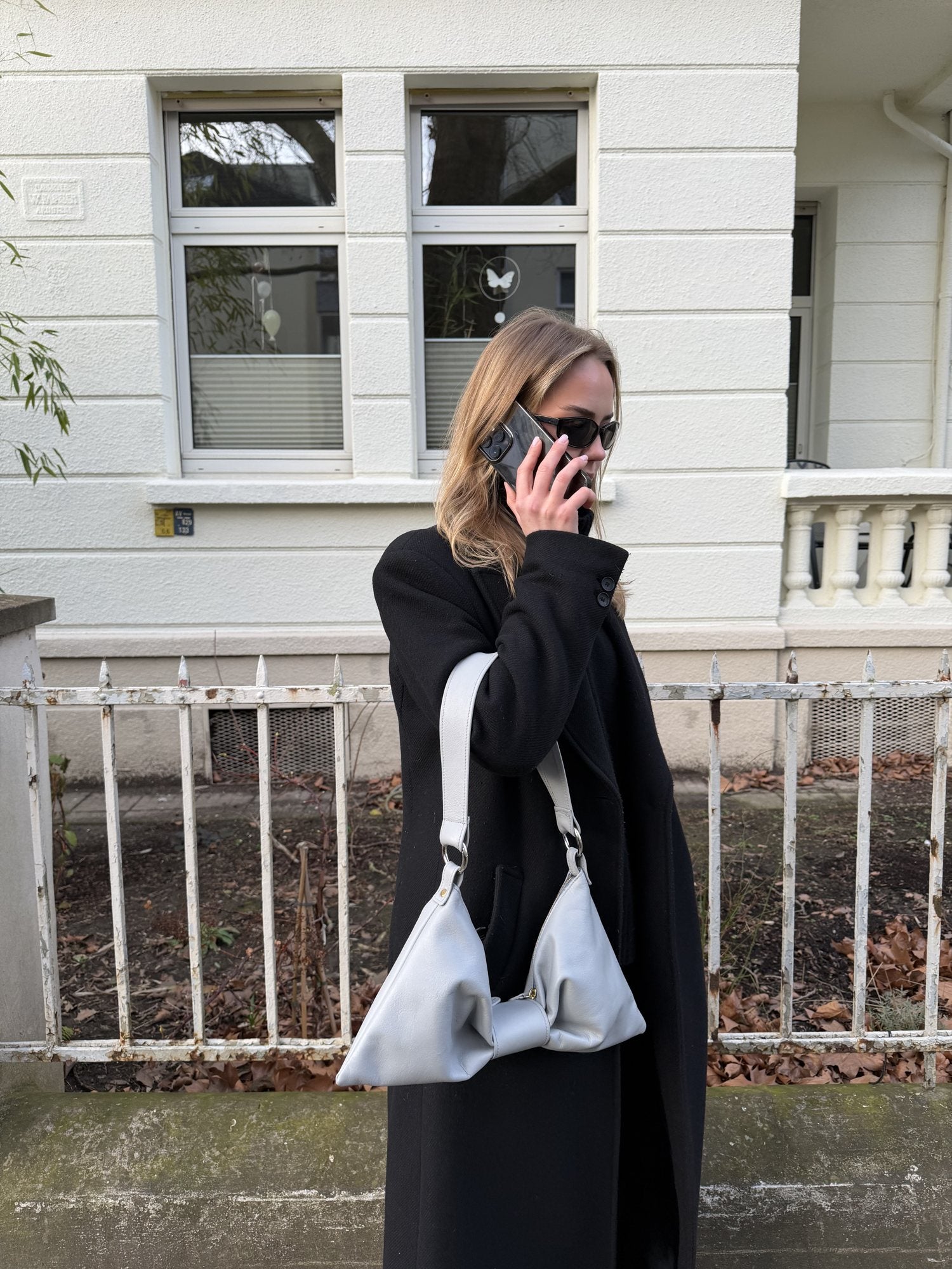 Bow Bag worn with a black coat